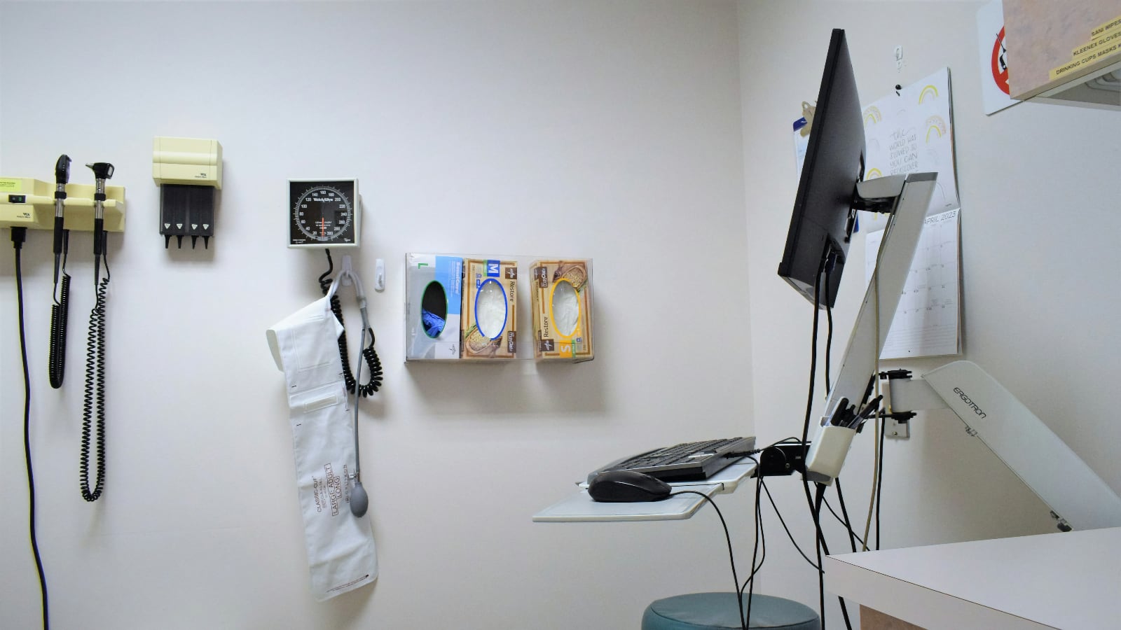 Sala de consulta médica con instrumentos de diagnóstico, tensiómetro y una computadora
