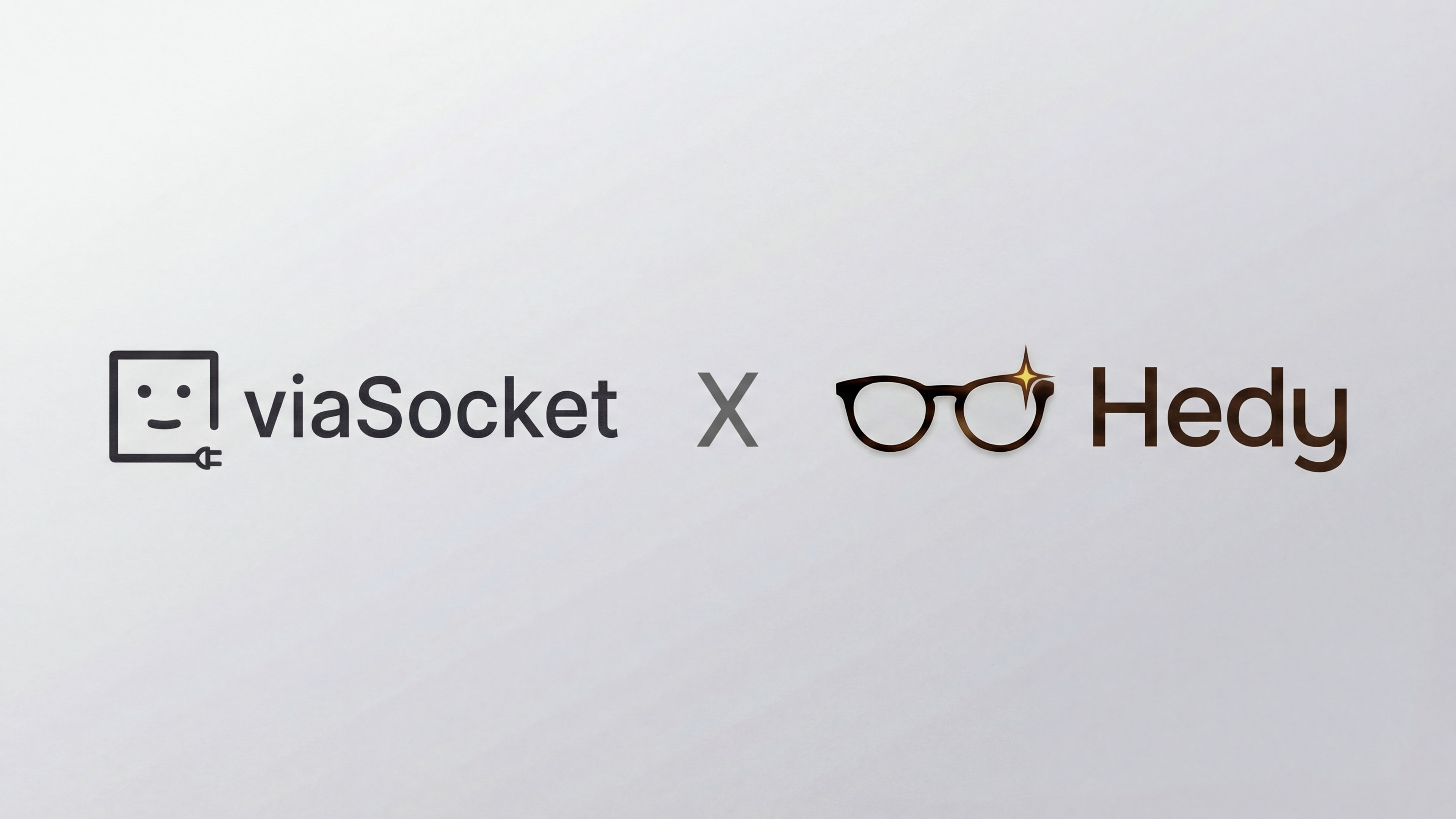 Logos de viaSocket y Hedy uno al lado del otro con una X entre ellos sobre un fondo claro